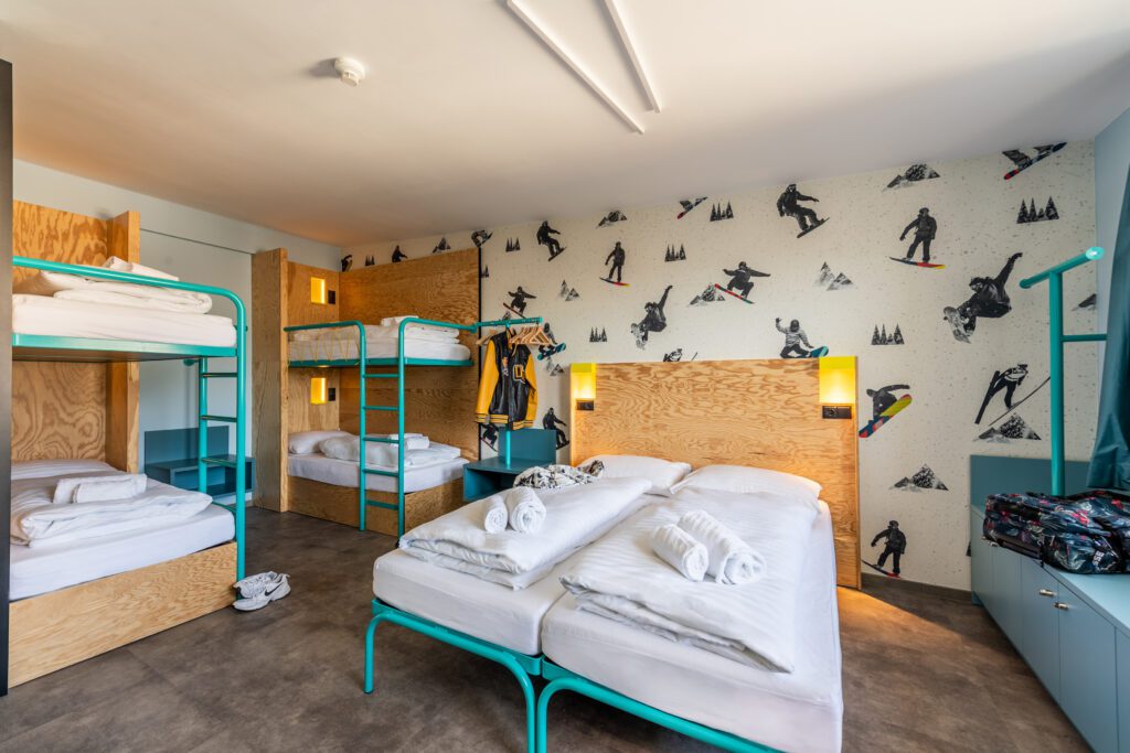 MEININGER Hotel Innsbruck Zentrum: shared room with bunk and twin bed, wall decor