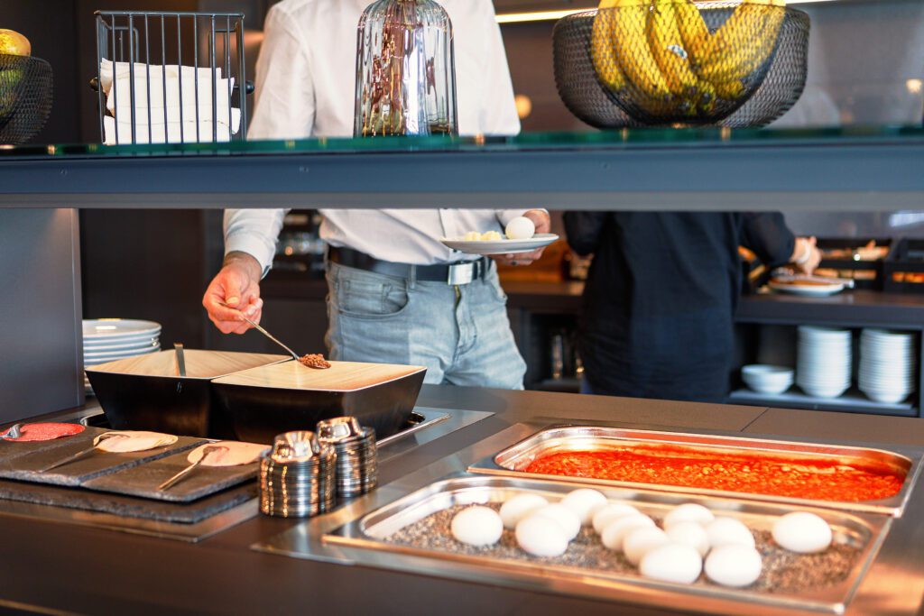 MEININGER Hotel Dresden Zentrum: Breakfast buffet with eggs, sausages, and fruit