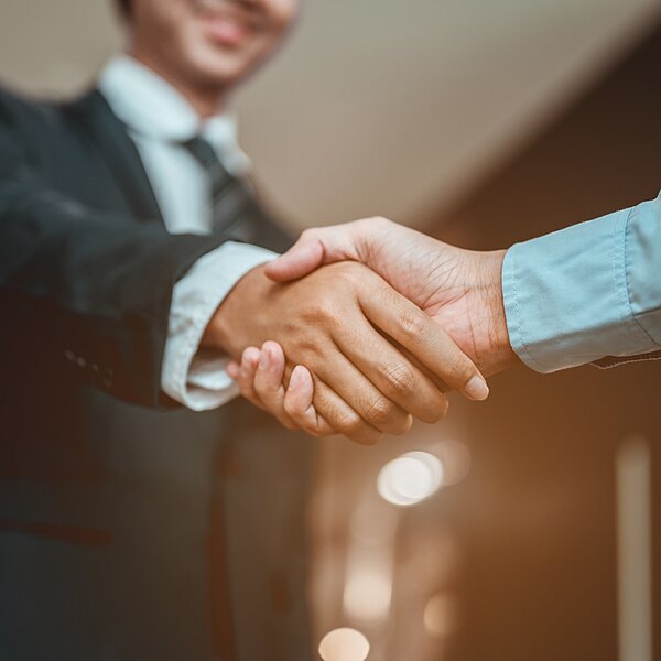 Handshake representing MEININGER Hotel’s collaboration with parent company Holidaybreak