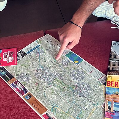 Un invité pointant sur une carte d'Europe avec toutes les destinations MEININGER